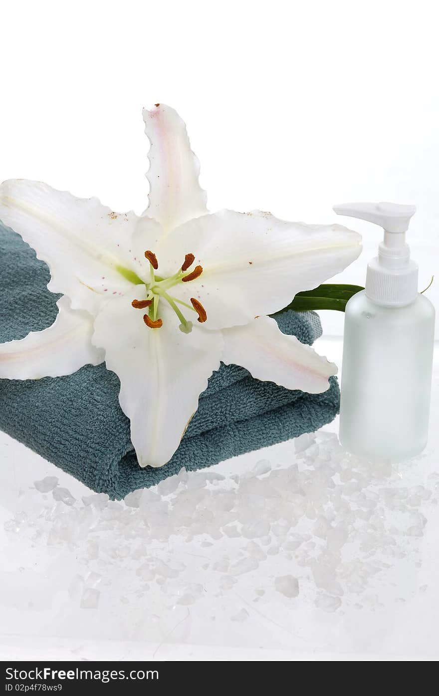 Bottles of shower gel with white lily on the white towel. Bottles of shower gel with white lily on the white towel