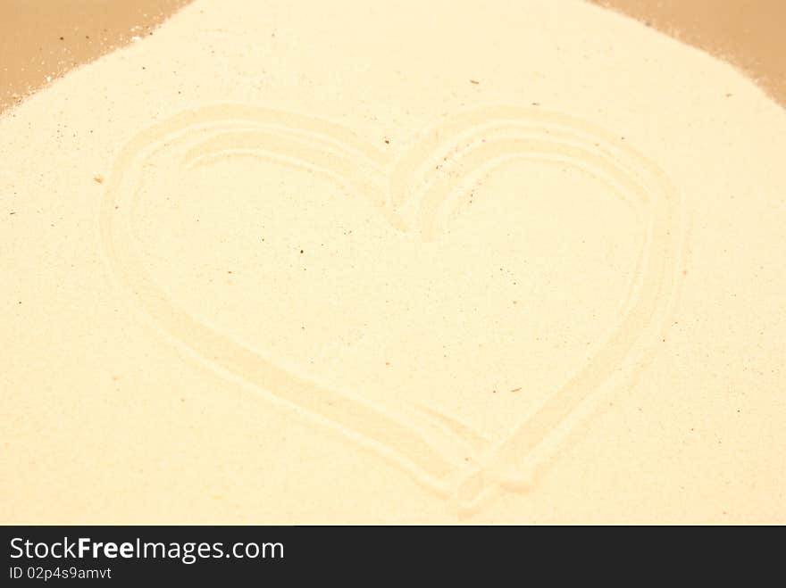 Heart shape on brown sand