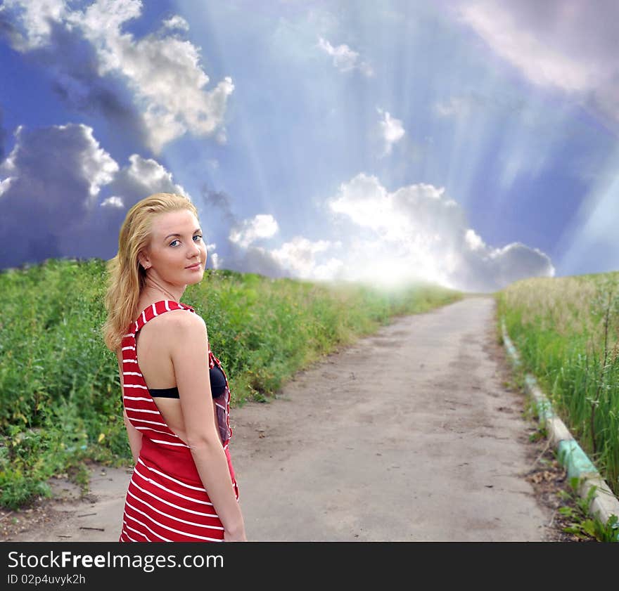 The beautiful girl with blue eyes in a grass. Sunrise.