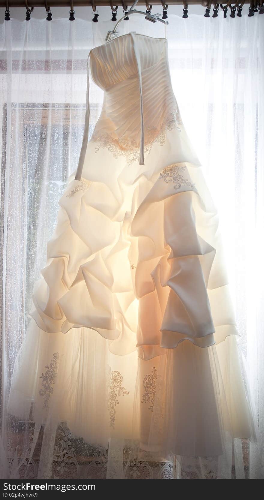 Wedding dress hanging in a window.