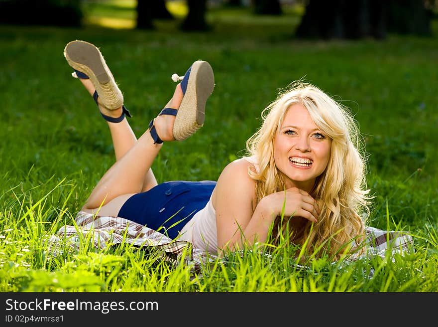 Young blond on a blanket in the green park. Young blond on a blanket in the green park