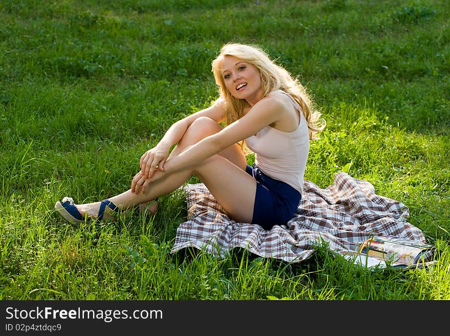 Young blond on a blanket in the green park. Young blond on a blanket in the green park