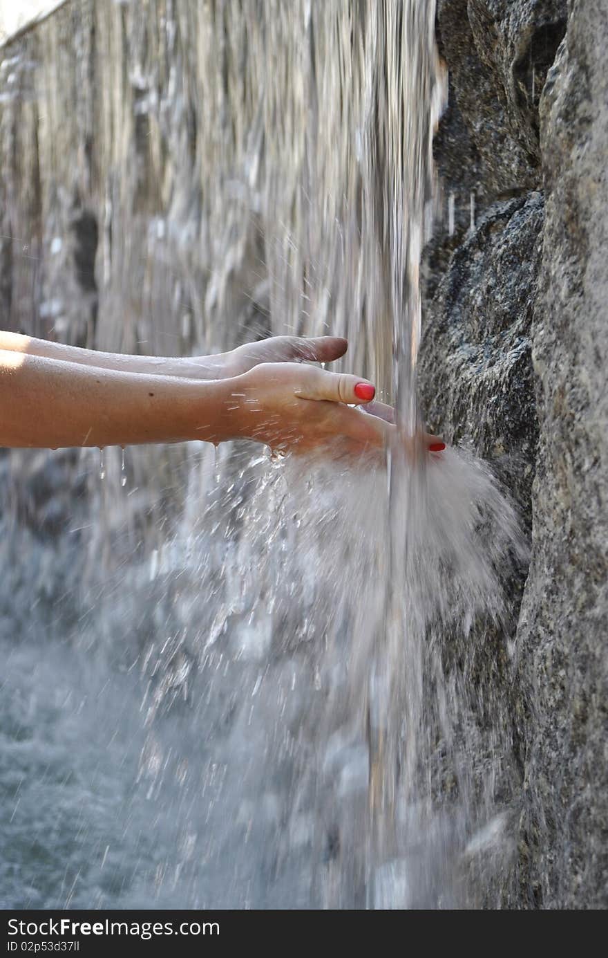 This photo shows a woman's hands in the fountain. This photo shows a woman's hands in the fountain