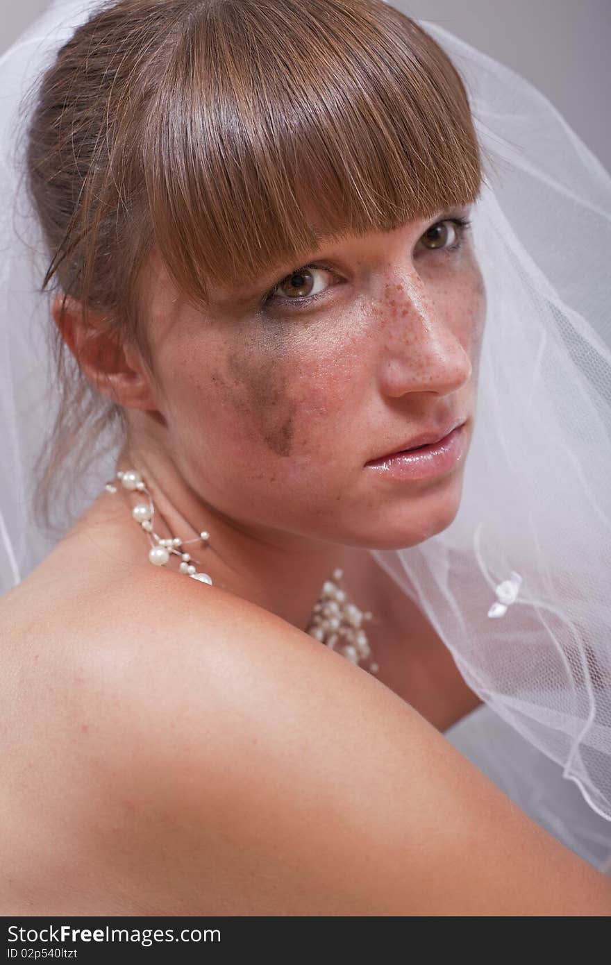 Portrait of sad bride over grey background