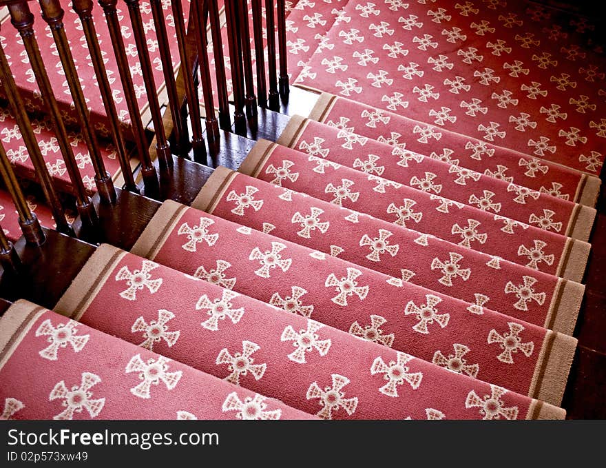 Old wooden imperial staircase with a red carpet