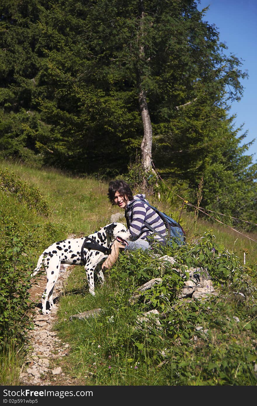 Boy with Dalmatian dog on a mountain hiking trail. Boy with Dalmatian dog on a mountain hiking trail