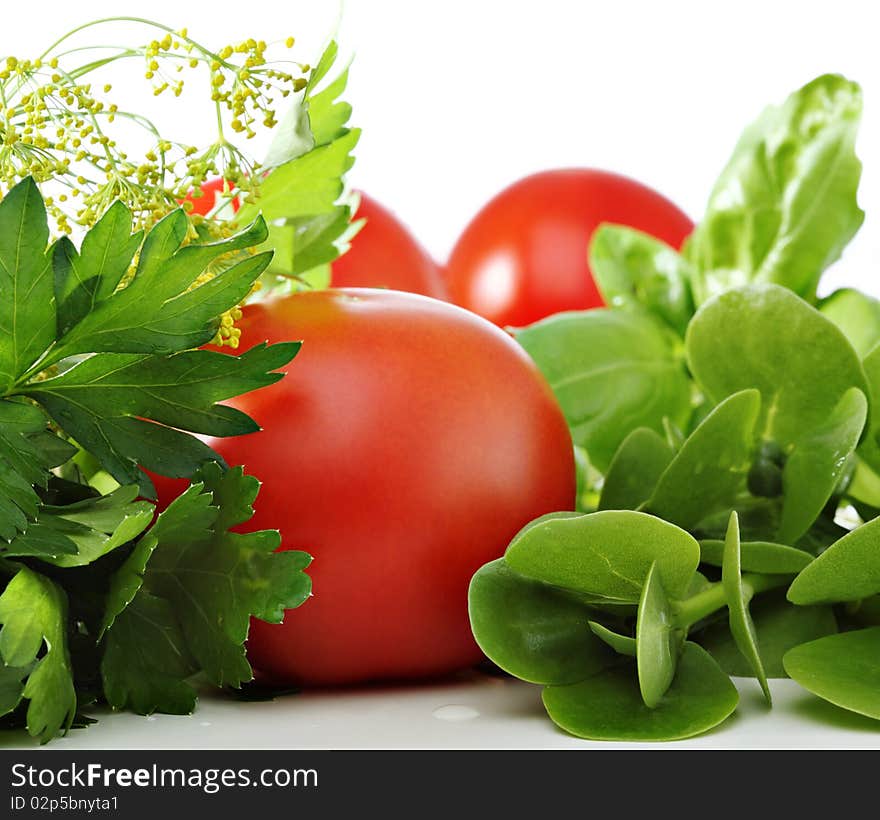 Tomatoes and green herbs on white background. Tomatoes and green herbs on white background