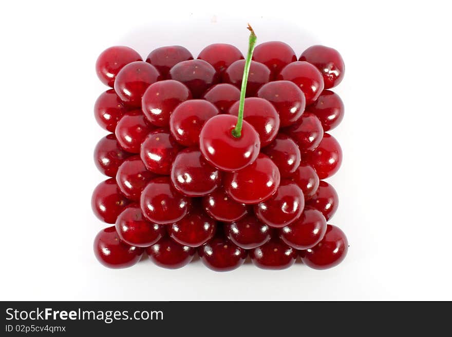 Sour cherries ordered in form of a pyramid top view isolated on white