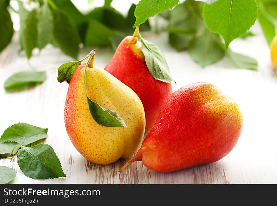 Fresh pears with leaves  on the white wooden  table