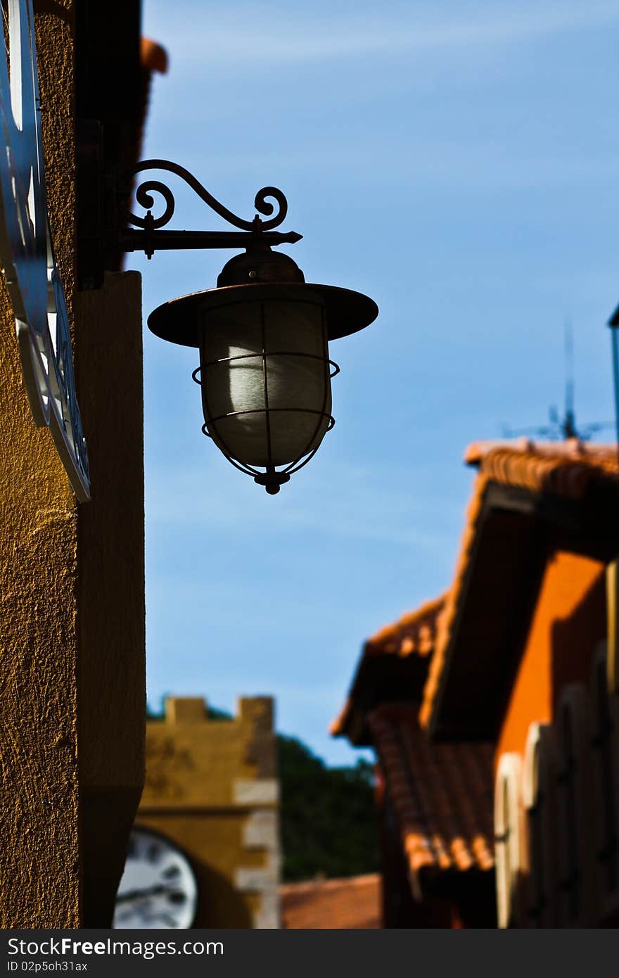 Lantern that setting on wall for giving lighting beside building with blue sky background. Lantern that setting on wall for giving lighting beside building with blue sky background