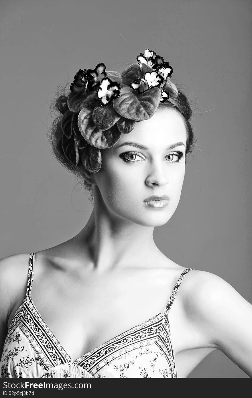 Beautiful girl with a wreath of flowers on her head on the white background