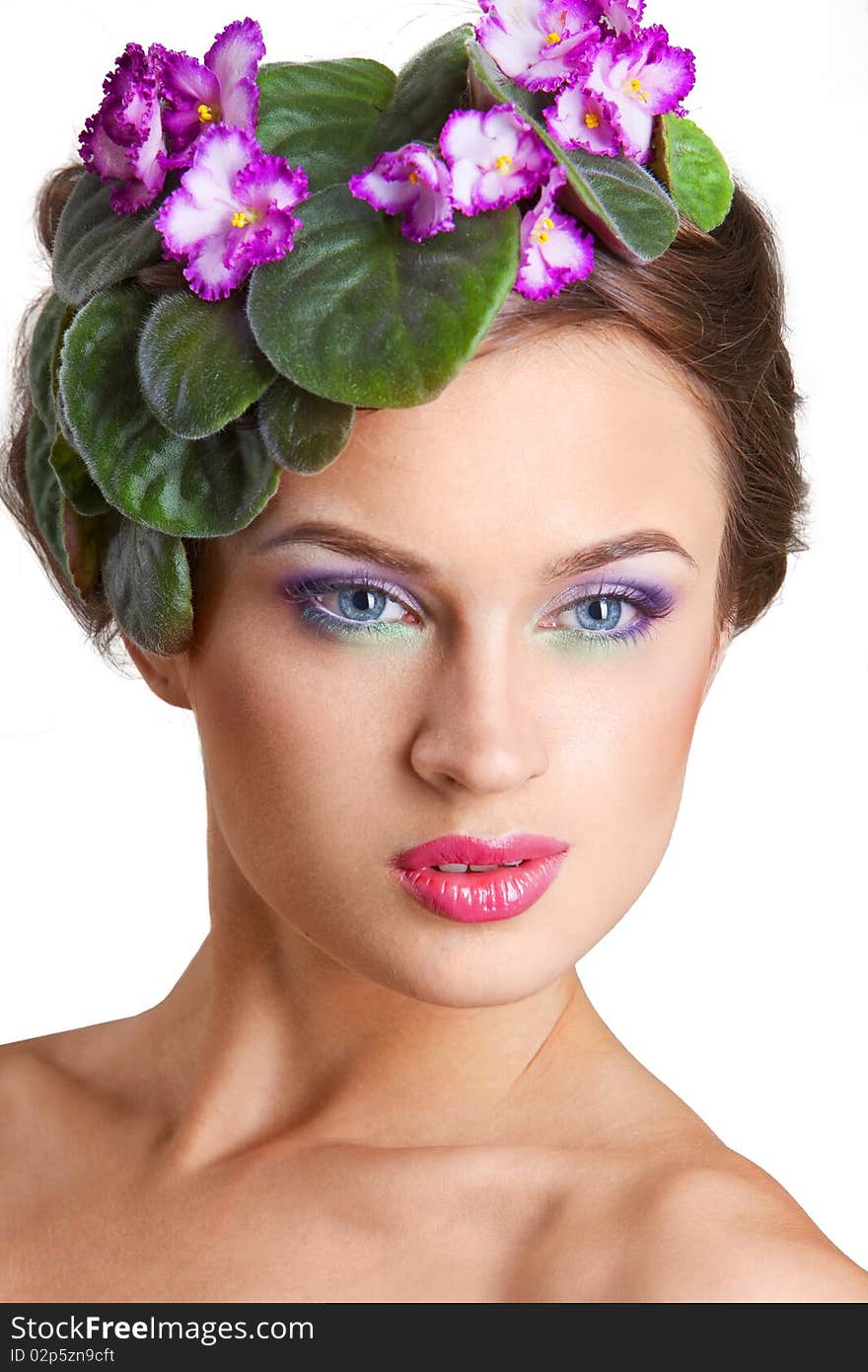 Beautiful girl with a wreath of flowers on her head on the white background