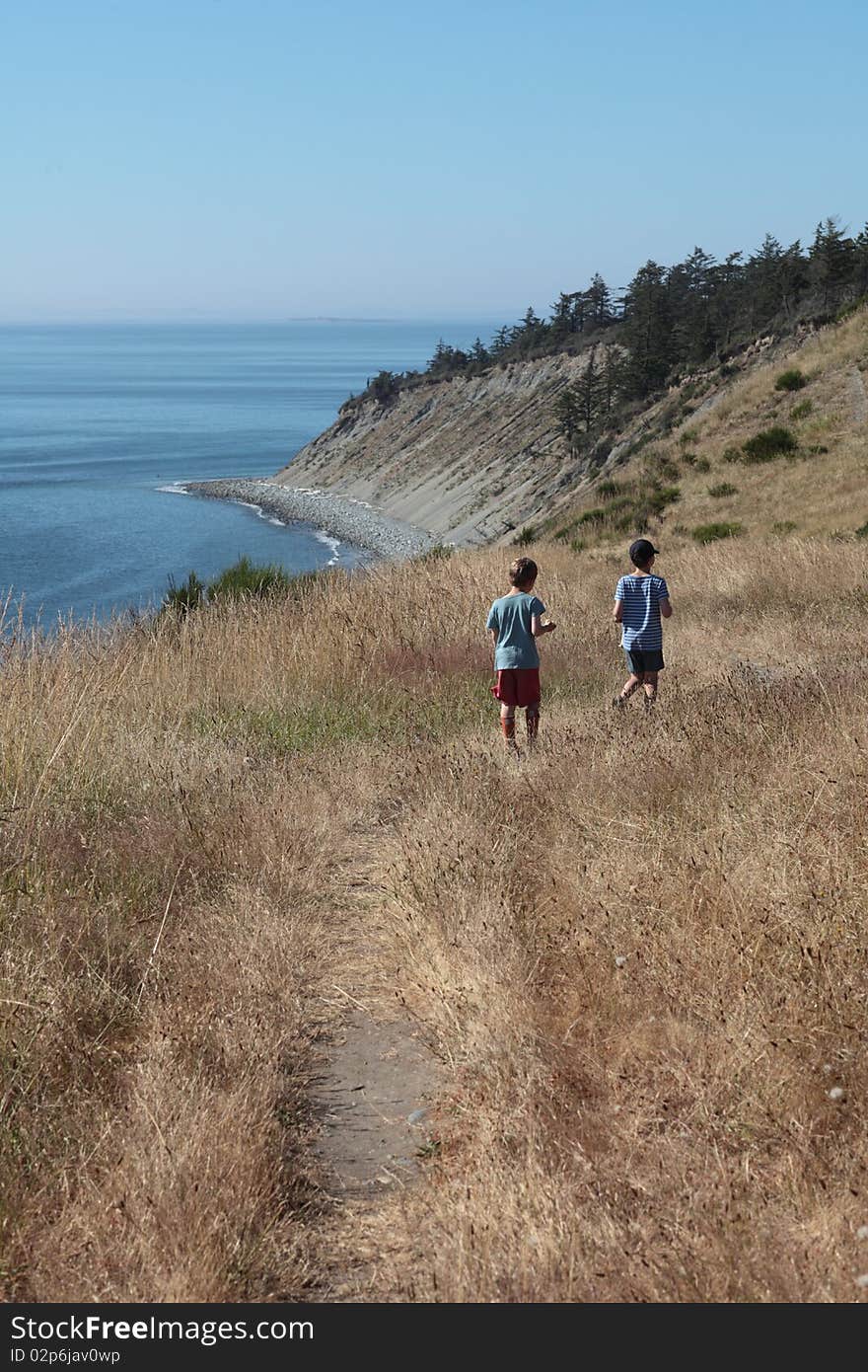 Boys hiking on a hill next to the ocean