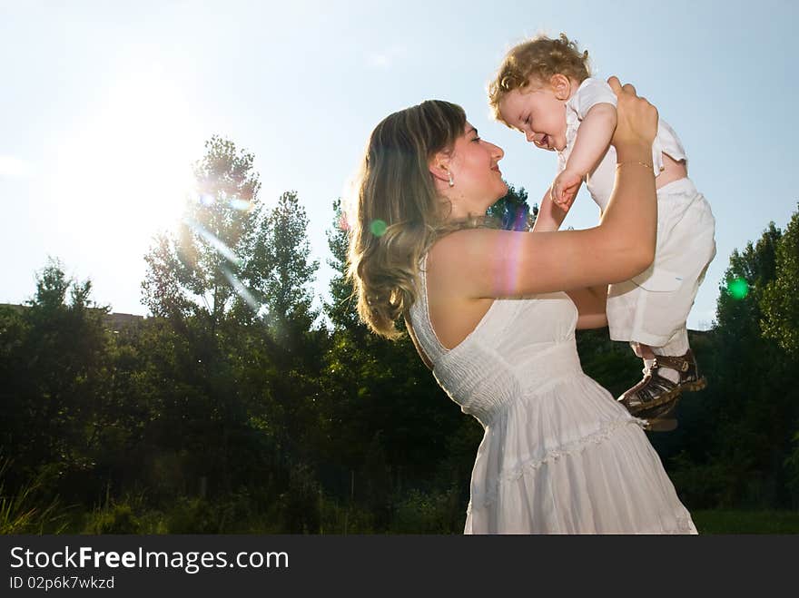 A young attractive woman holds her little cute baby in his hands. A young attractive woman holds her little cute baby in his hands