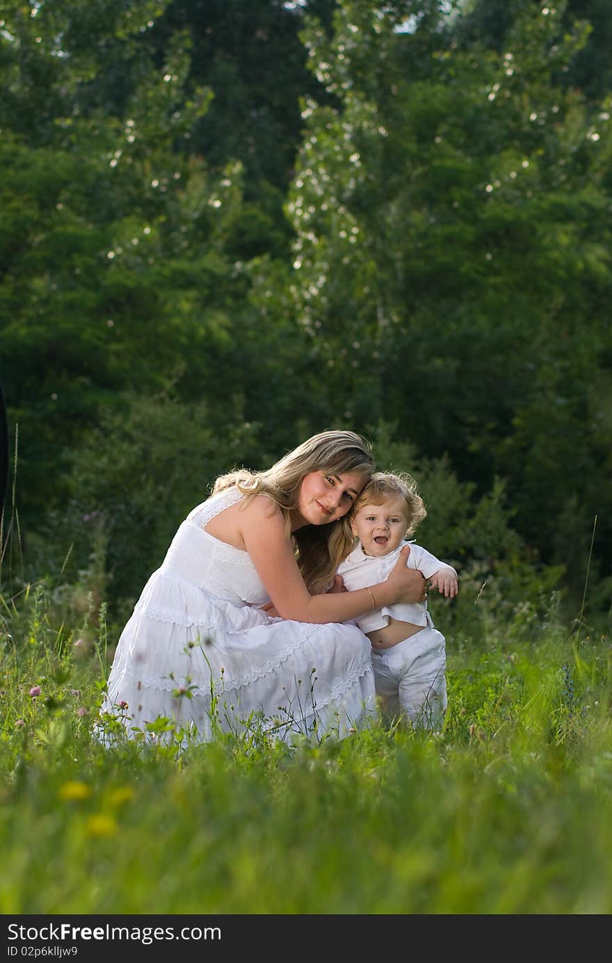 A young attractive woman holds her little cute baby in his hands. A young attractive woman holds her little cute baby in his hands