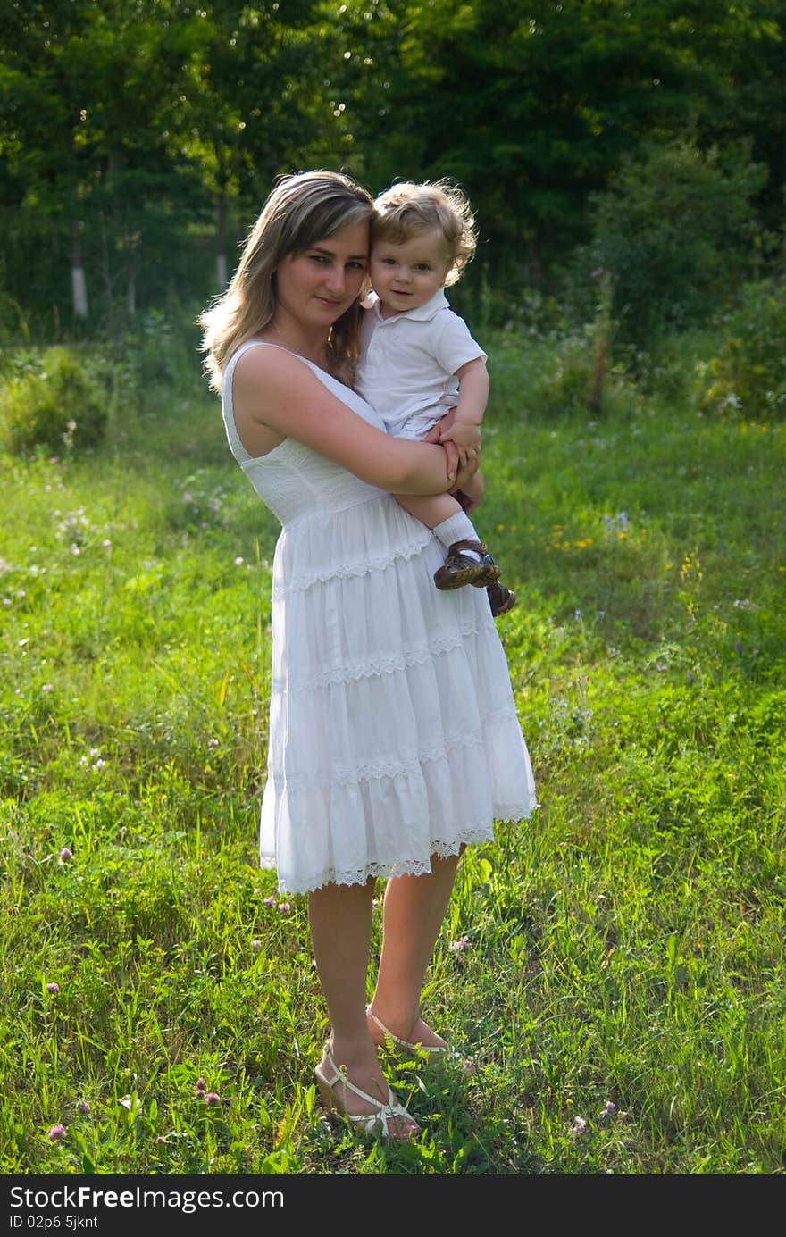 A young attractive woman holds her little cute baby in his hands. A young attractive woman holds her little cute baby in his hands