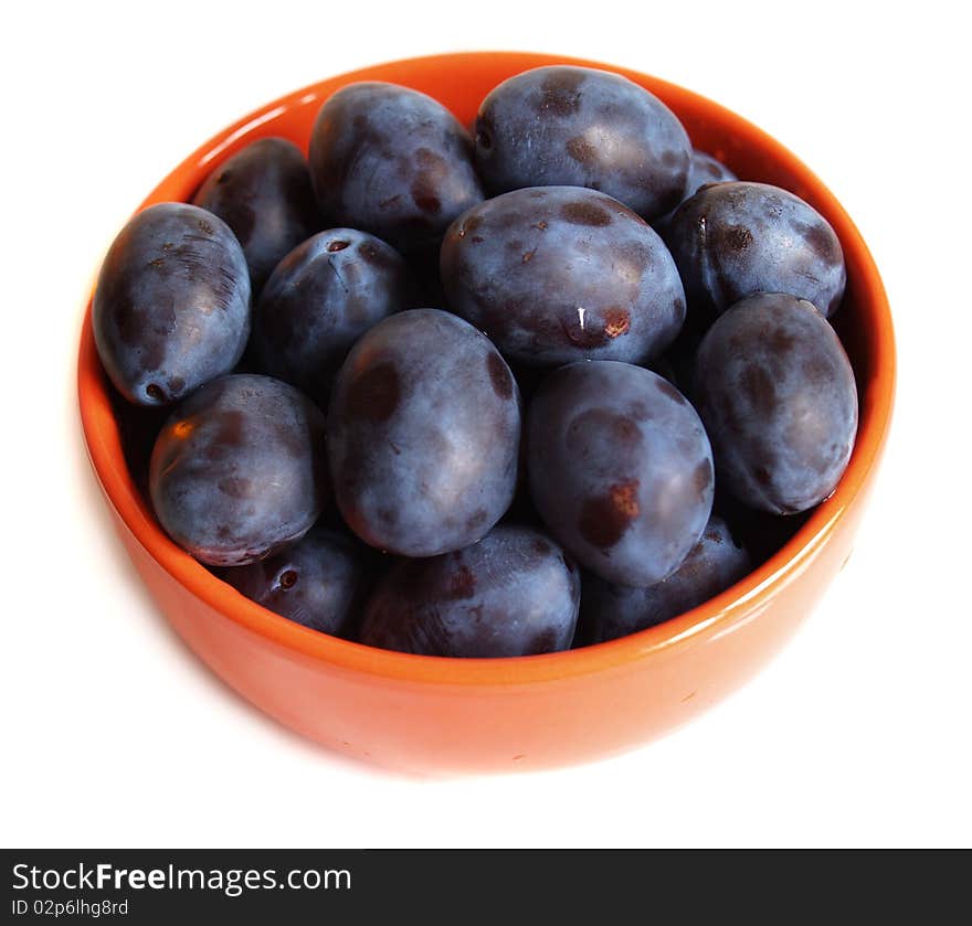 Juicy plums on the plate isolated on white background with drops of water. Juicy plums on the plate isolated on white background with drops of water