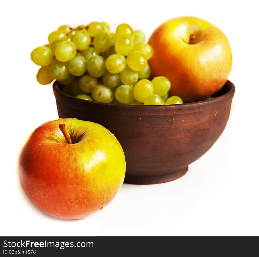 Grapes and apples in the clay plate