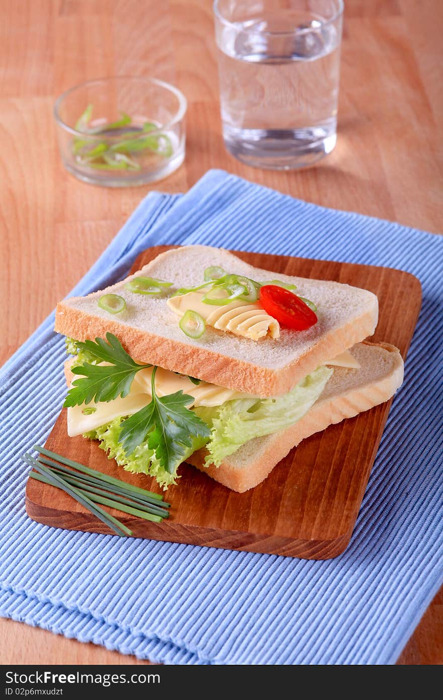 Cheese and lettuce between two slices of white bread. Cheese and lettuce between two slices of white bread