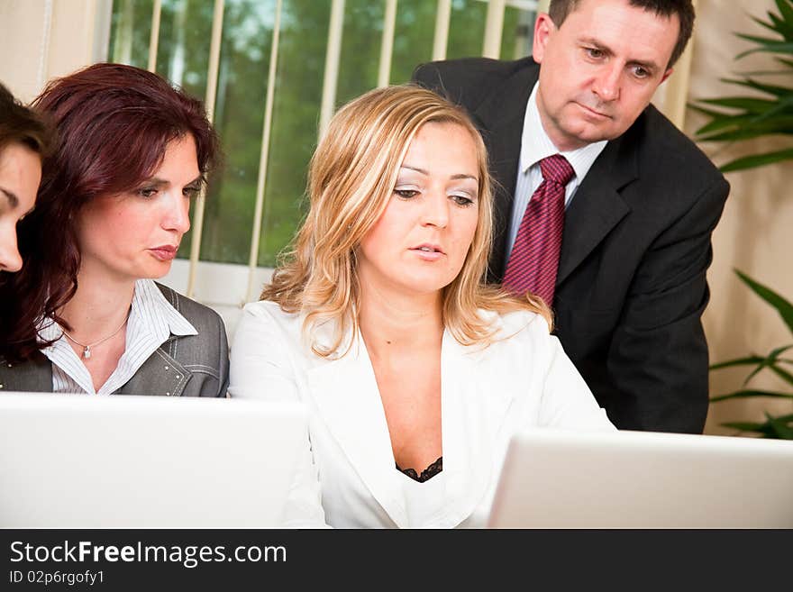 Group of four business people working on laptop at meeting. Group of four business people working on laptop at meeting