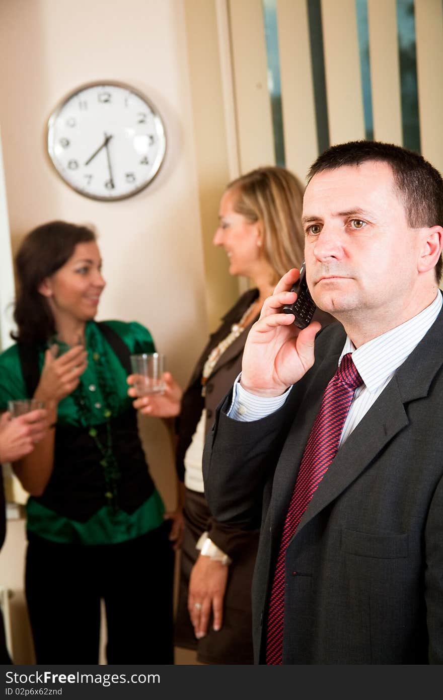 Business man on phone at meeting, women having conversation. Business man on phone at meeting, women having conversation