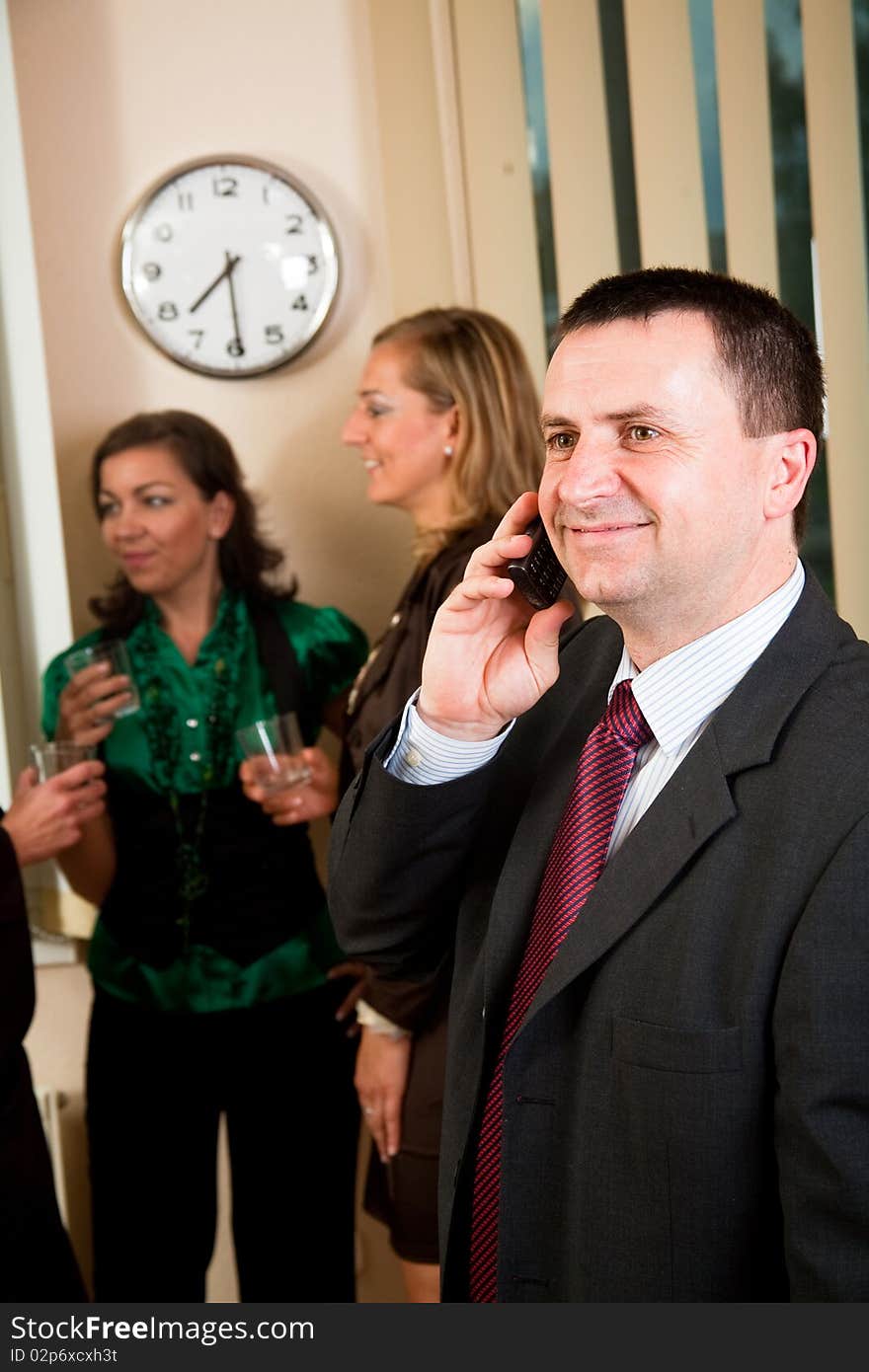 Business man on phone at meeting, women having conversation. Business man on phone at meeting, women having conversation