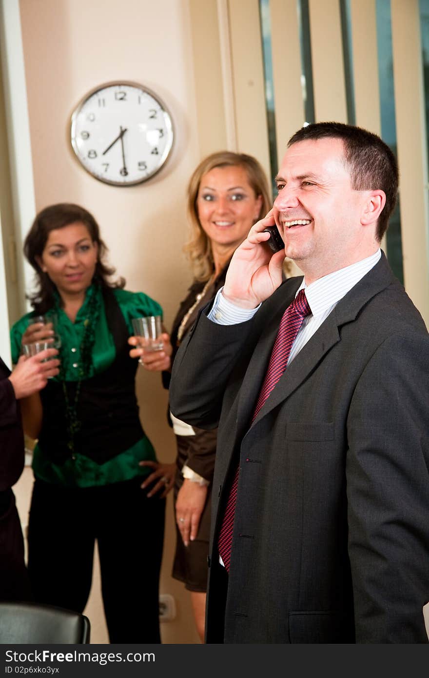 Business man on phone at meeting, women having conversation. Business man on phone at meeting, women having conversation