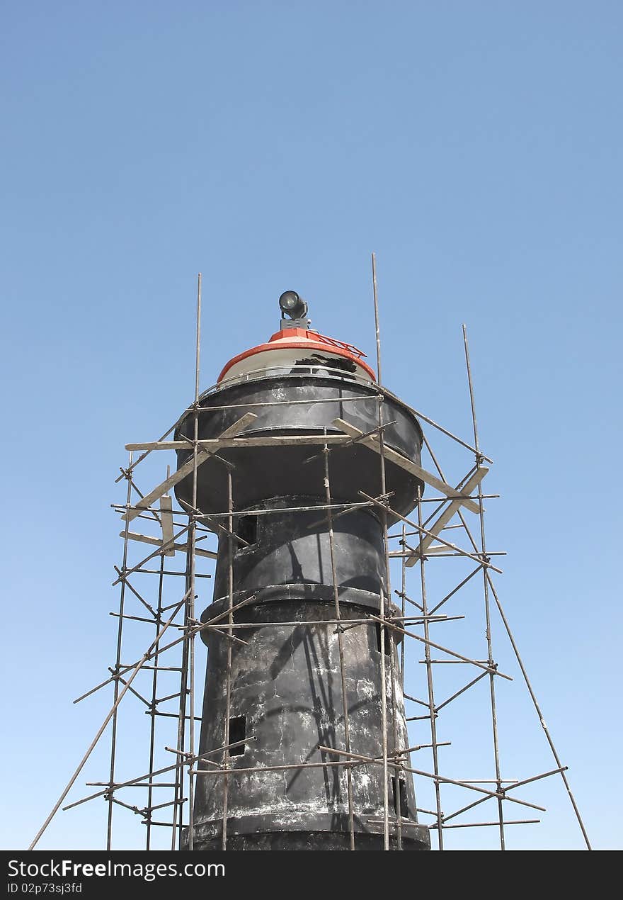 Scaffolding around a lighthouse tower. Scaffolding around a lighthouse tower