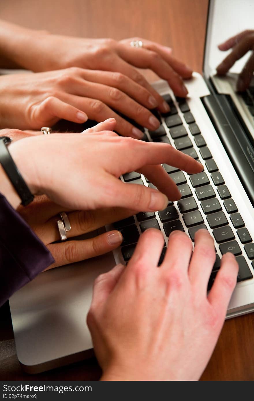 Hands of three business women workingon laptop in the office. Hands of three business women workingon laptop in the office