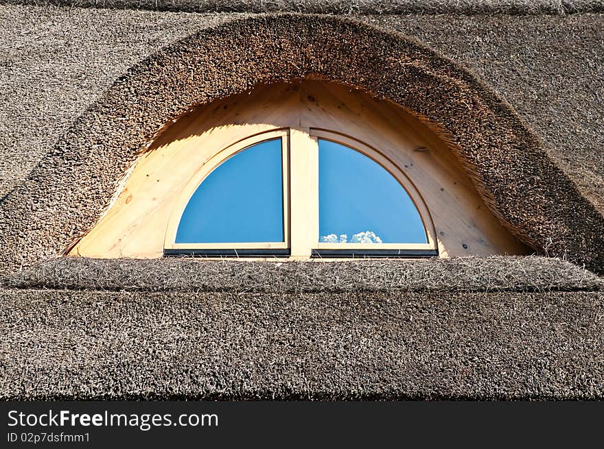 Wooden window on the straw roof