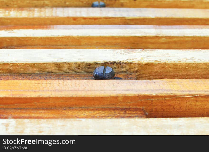 Screw hat sticks out of a wooden whetstone. Screw hat sticks out of a wooden whetstone