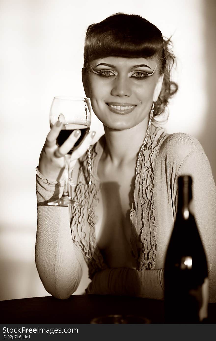 Cheerful girl with wineglass at table