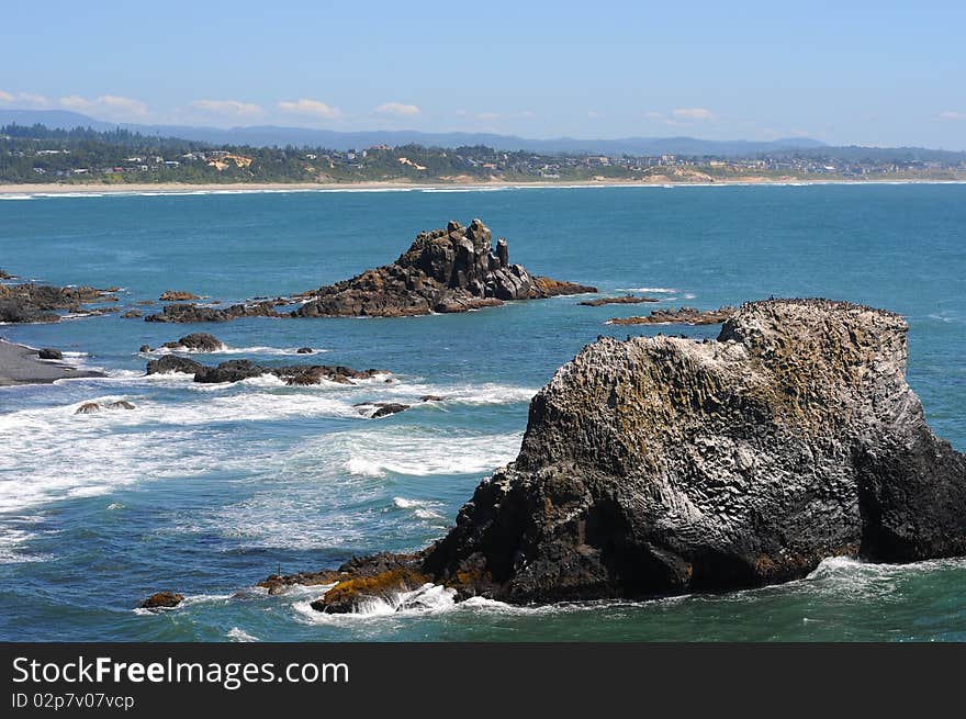 Large sea rocks with birds on them right on the oregon coast line.