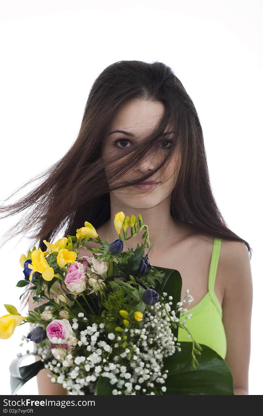 Beauty with a bunch of flowers, hair blowing in her face