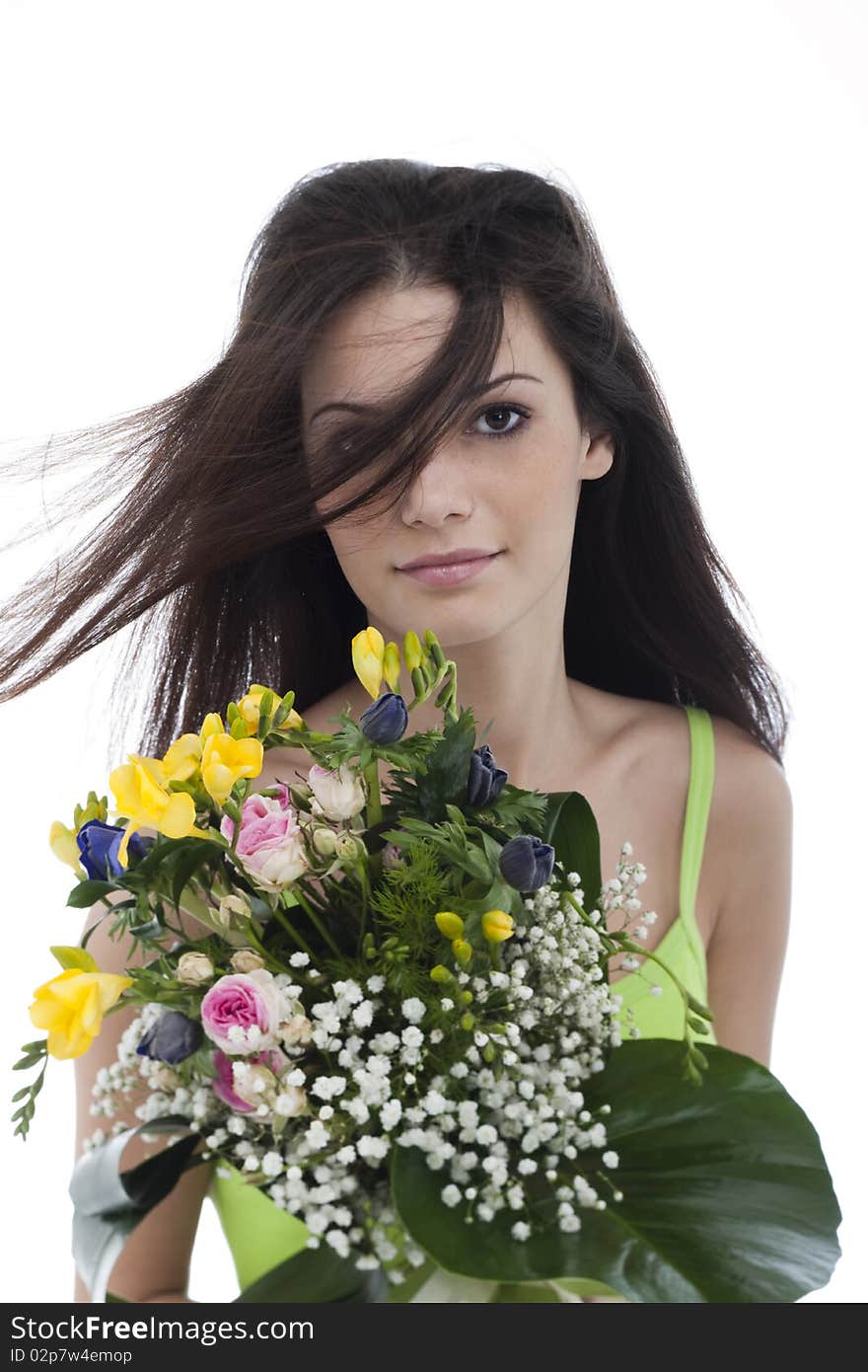 Beauty with a bunch of flowers, hair blowing in her face