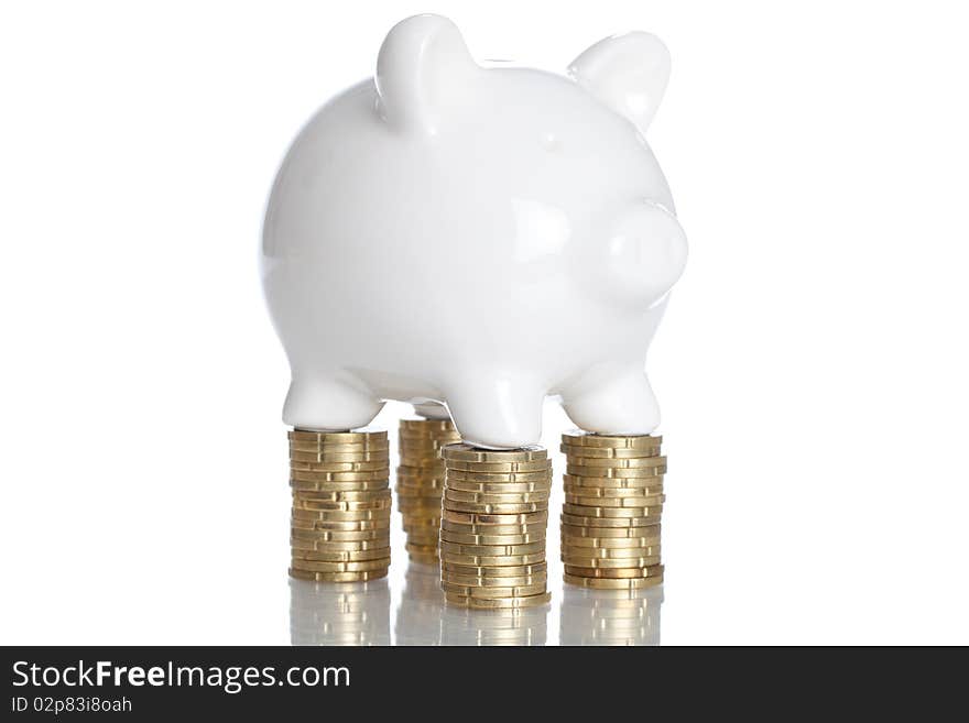 Piggy Bank standing on some stack of coins - isolated on a white backgorund