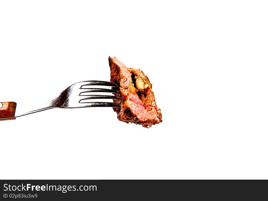 A piece of succulent steak on a fork ready to be eaten. A piece of succulent steak on a fork ready to be eaten