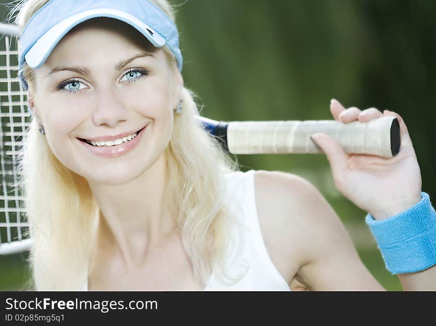 Female tennis player with a racket outdoors