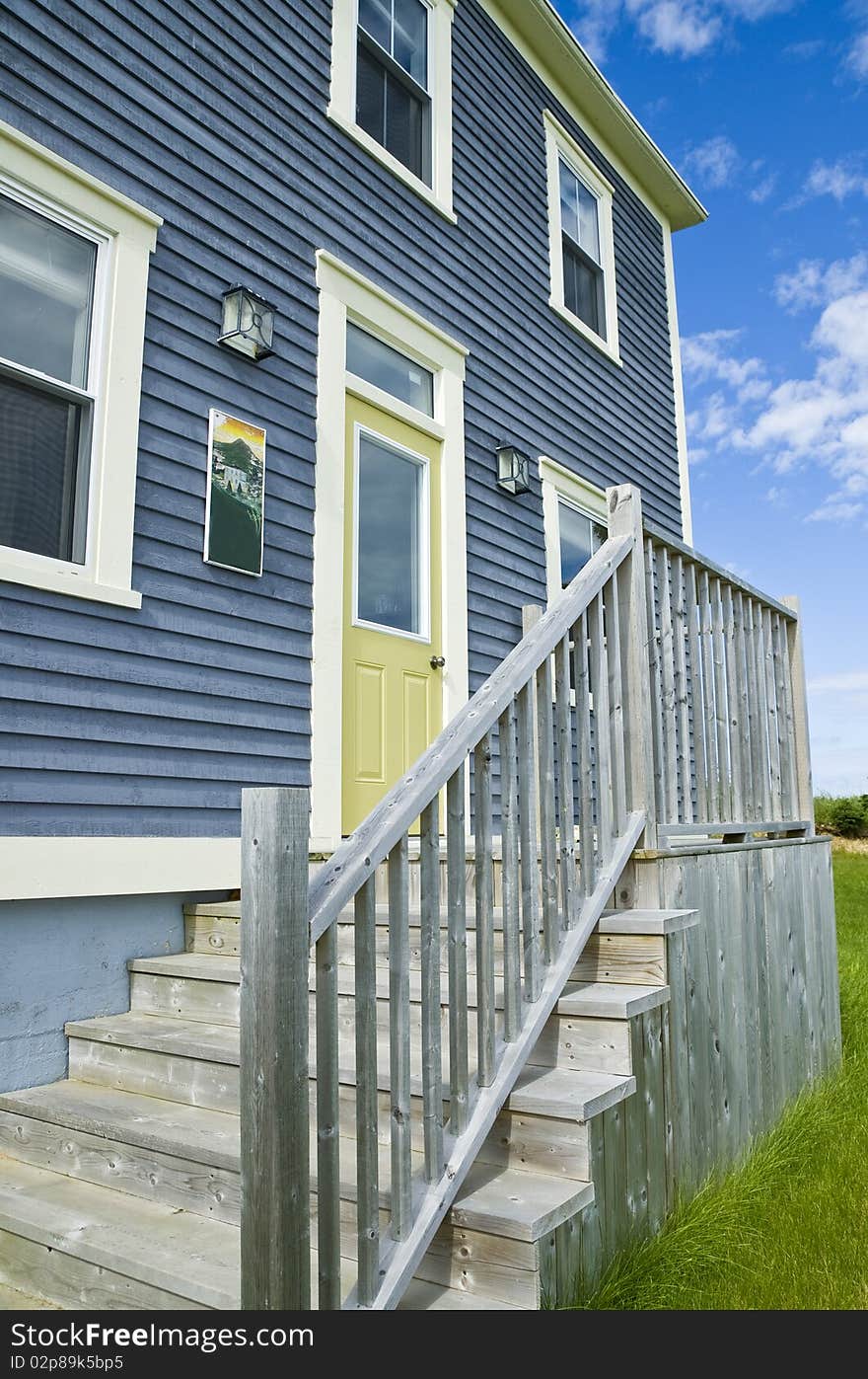 A traditional clapboard home with dramatic blue sky. A traditional clapboard home with dramatic blue sky.