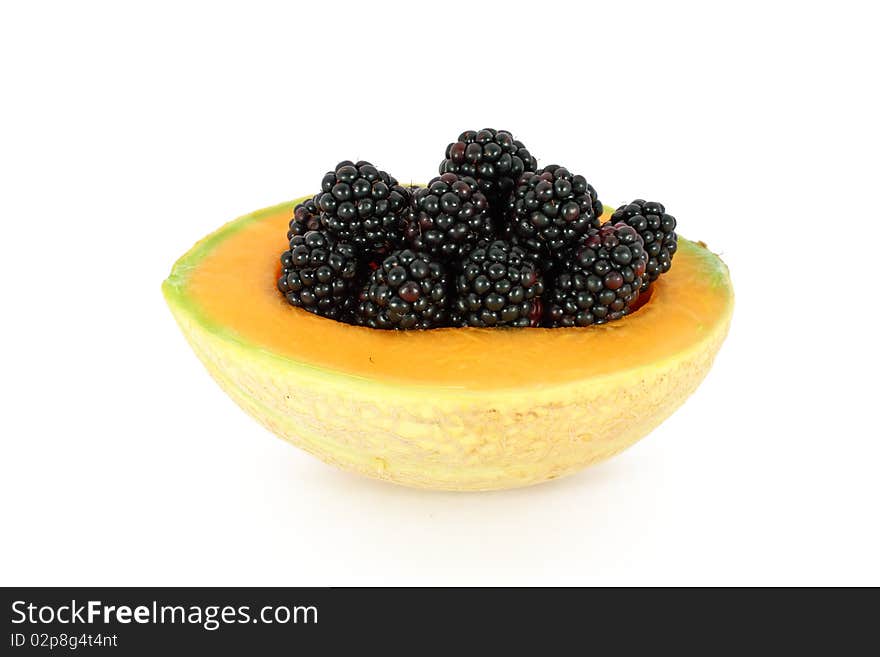 Ripe fresh blackberries in melon isolated on white