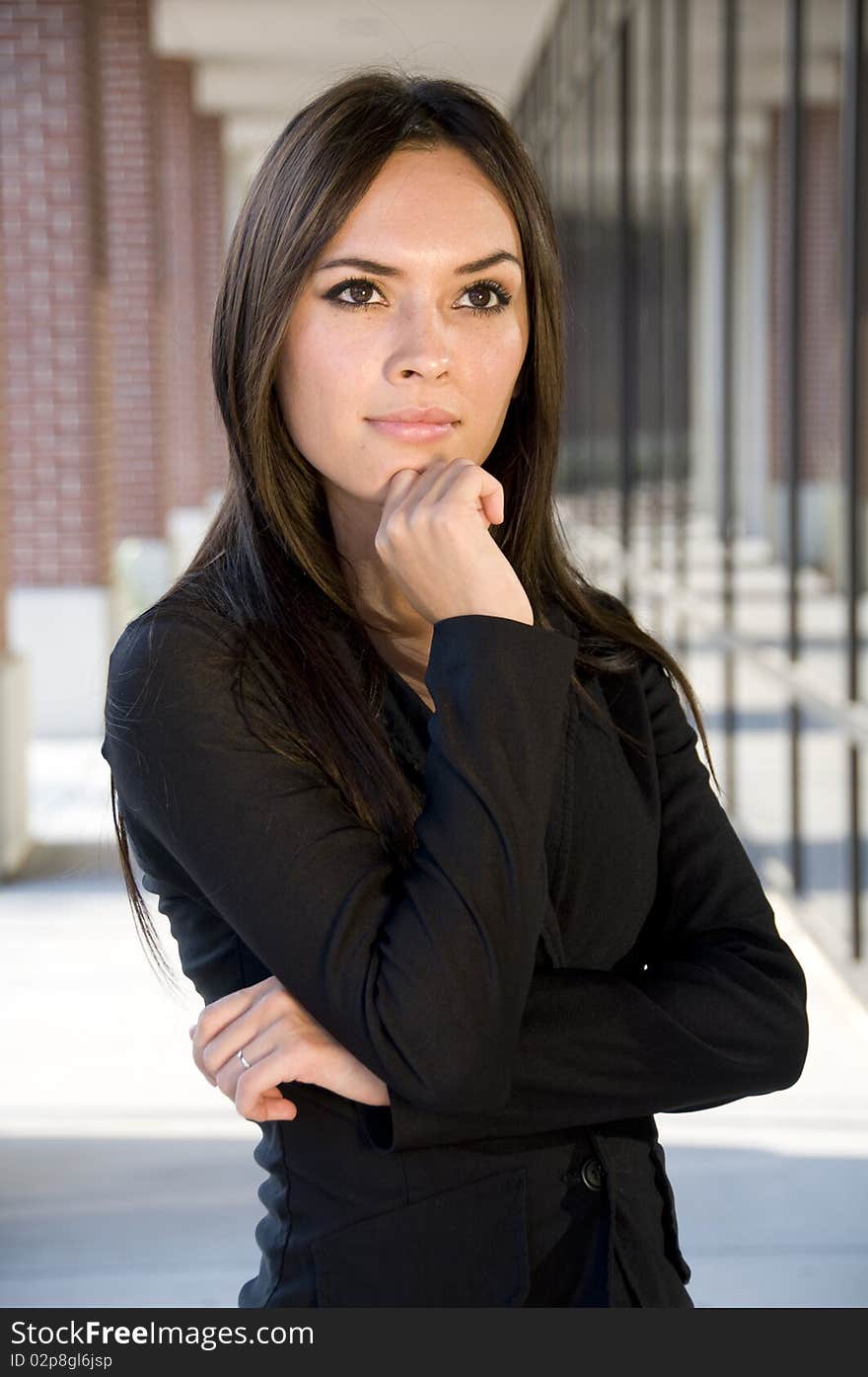 Attractive businesswoman thinking in front of an office building