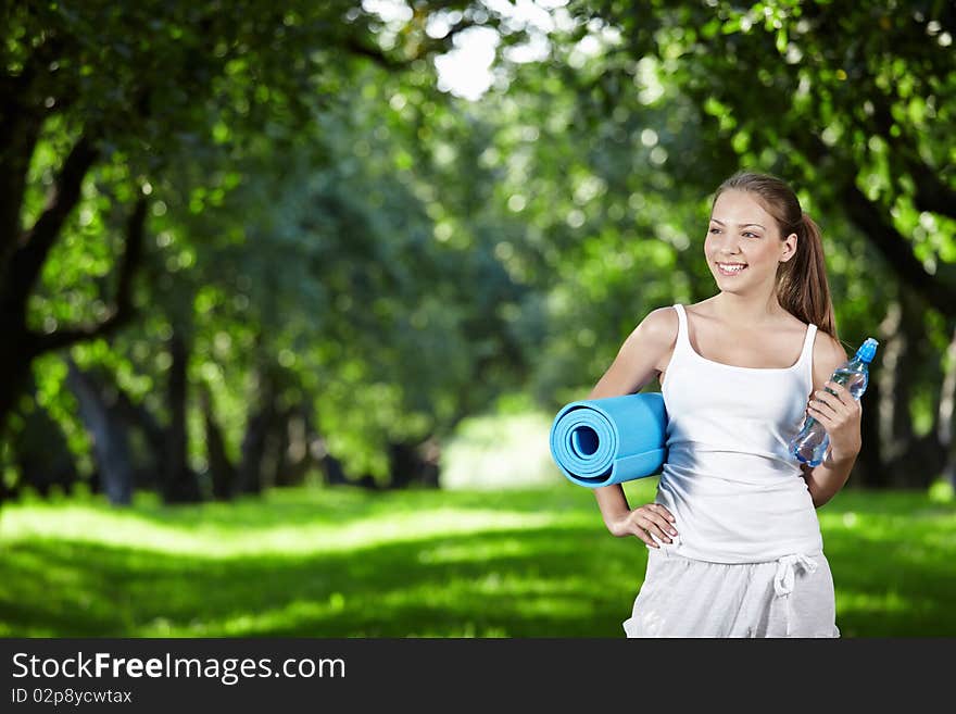 Young girl with a bottle of water and gymnastic mat. Young girl with a bottle of water and gymnastic mat