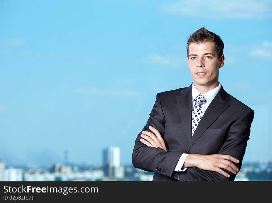 A young man in a suit against the sky. A young man in a suit against the sky