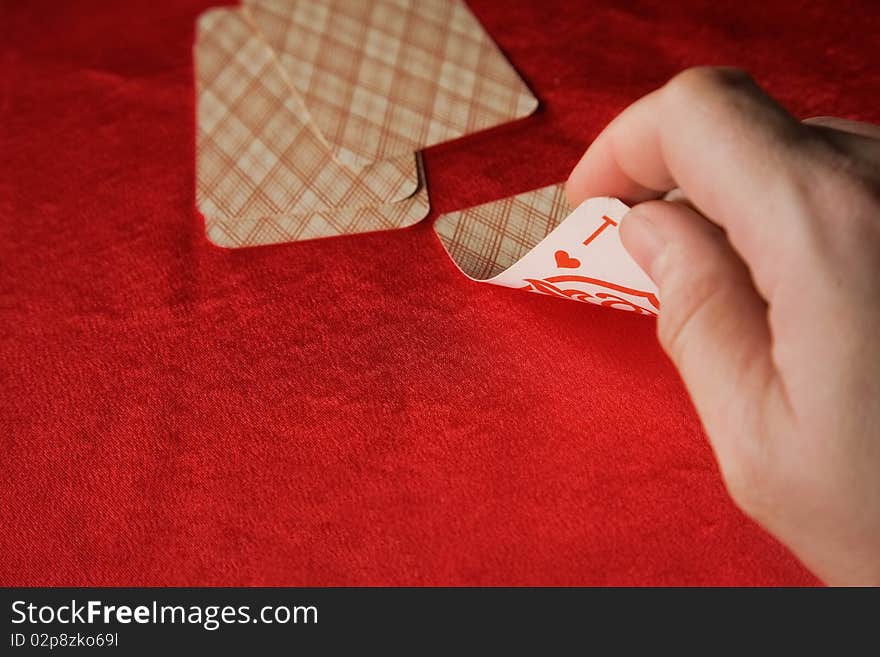 Player hold poker cards. The vintage poker cards on red table