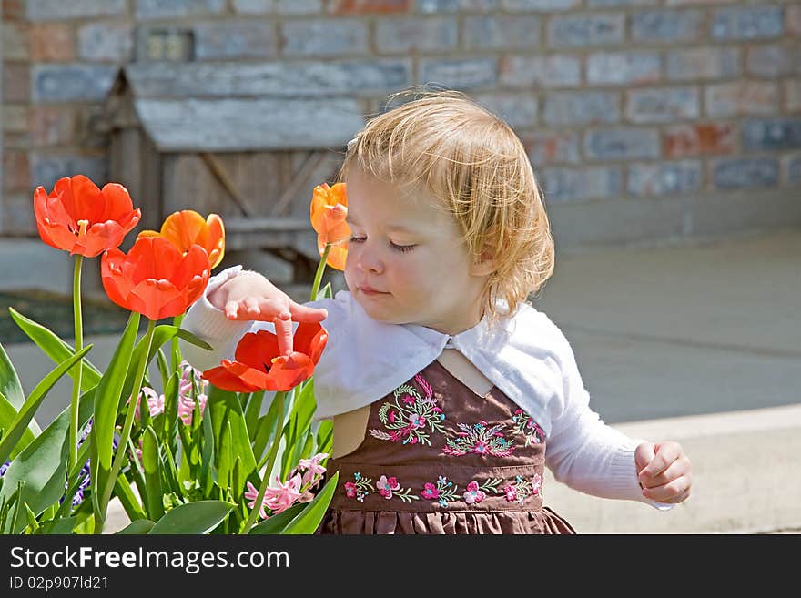 Little Girl Sitting Outside Enjoying Flowers. Little Girl Sitting Outside Enjoying Flowers