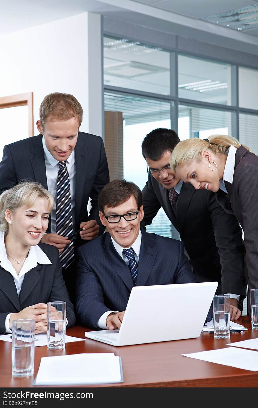 Employees with the boss looking at laptop monitor. Employees with the boss looking at laptop monitor