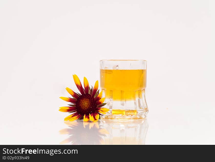 A tiny mug of honey with a red and yellow flower. A tiny mug of honey with a red and yellow flower