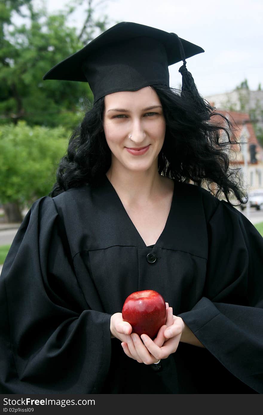 Caucasian student girl in gown with apple