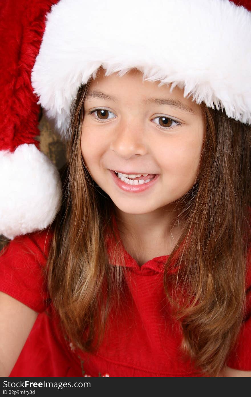 Cute brunette girl wearing a fluffy christmas hat. Cute brunette girl wearing a fluffy christmas hat