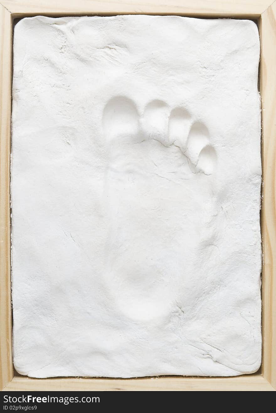 Small child memory footprint on clay in wooden frame. Small child memory footprint on clay in wooden frame